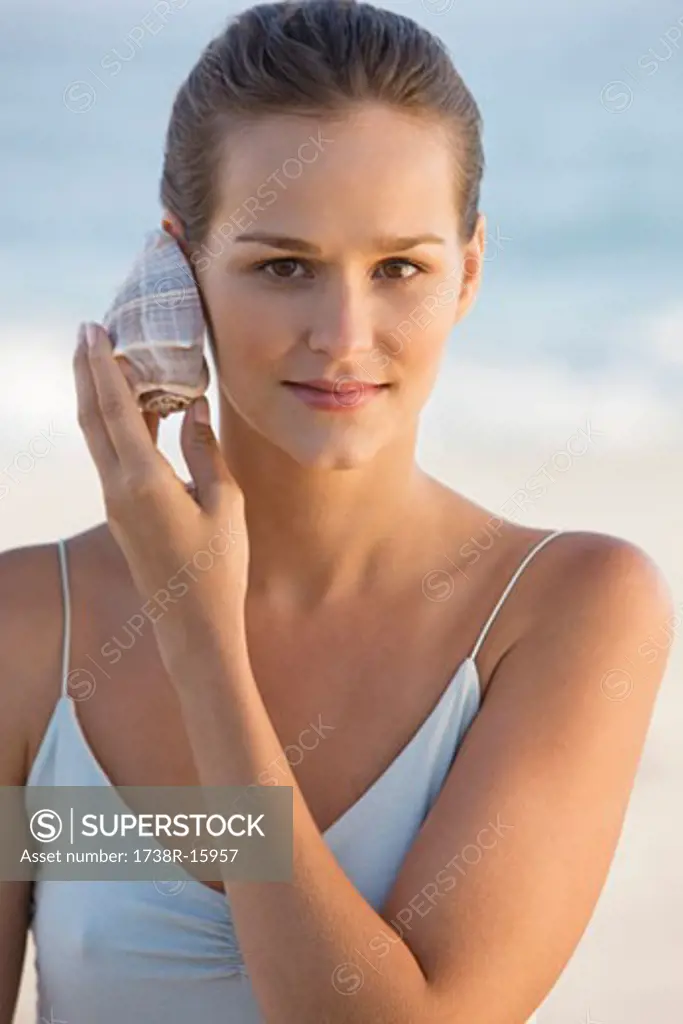 Woman listening to a conch shell