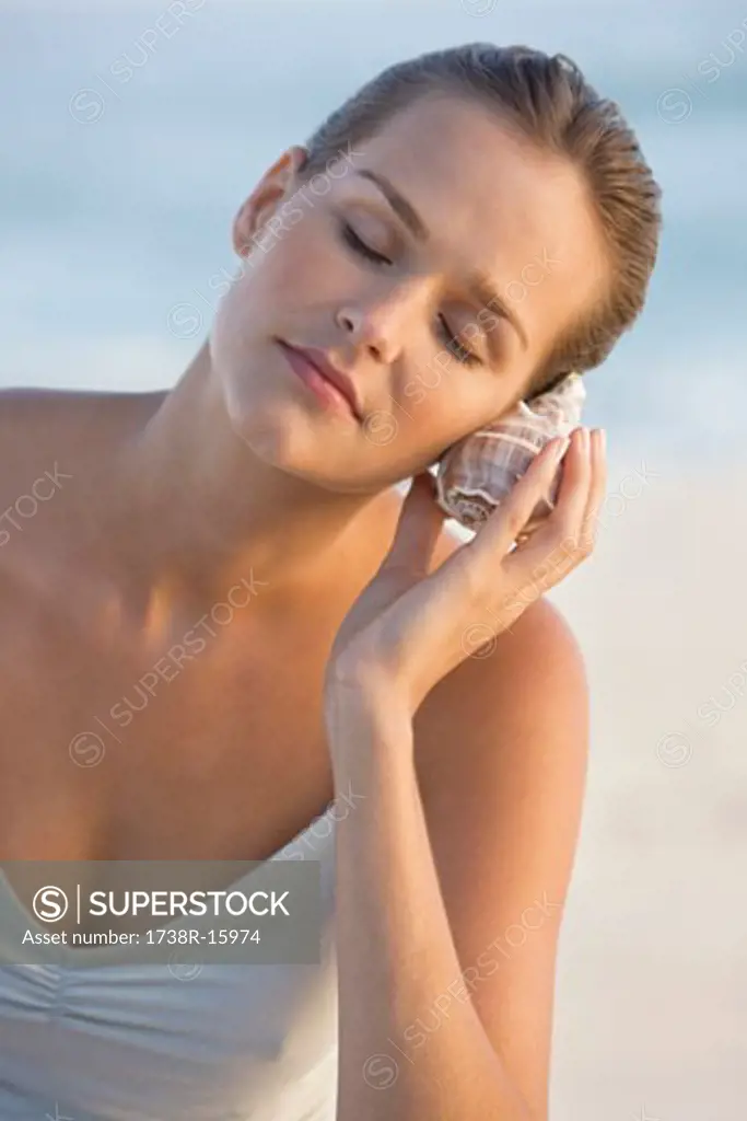 Woman listening to a conch shell