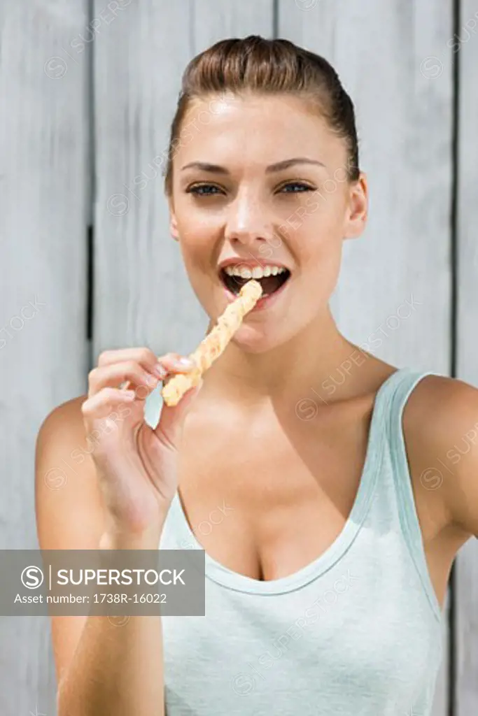 Portrait of a woman eating a breadstick