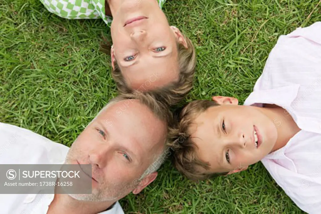 Boy with his parents lying on grass in a park
