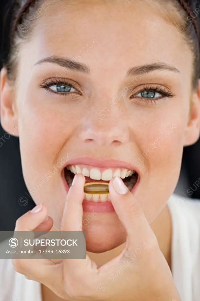 Portrait of a woman taking an Omega-3 capsule