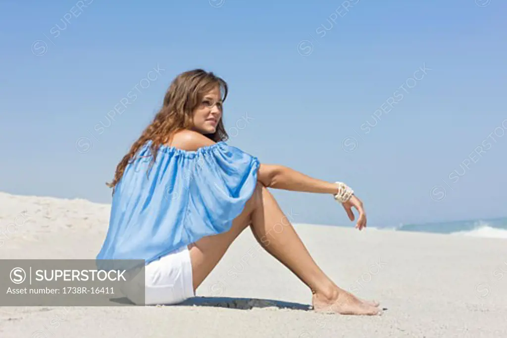 Woman sitting on the beach and thinking