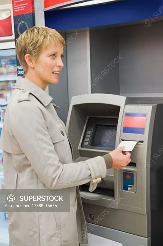 Woman receiving a transaction slip from an ATM