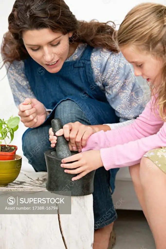 Women and her daughter with a mortar and pestle