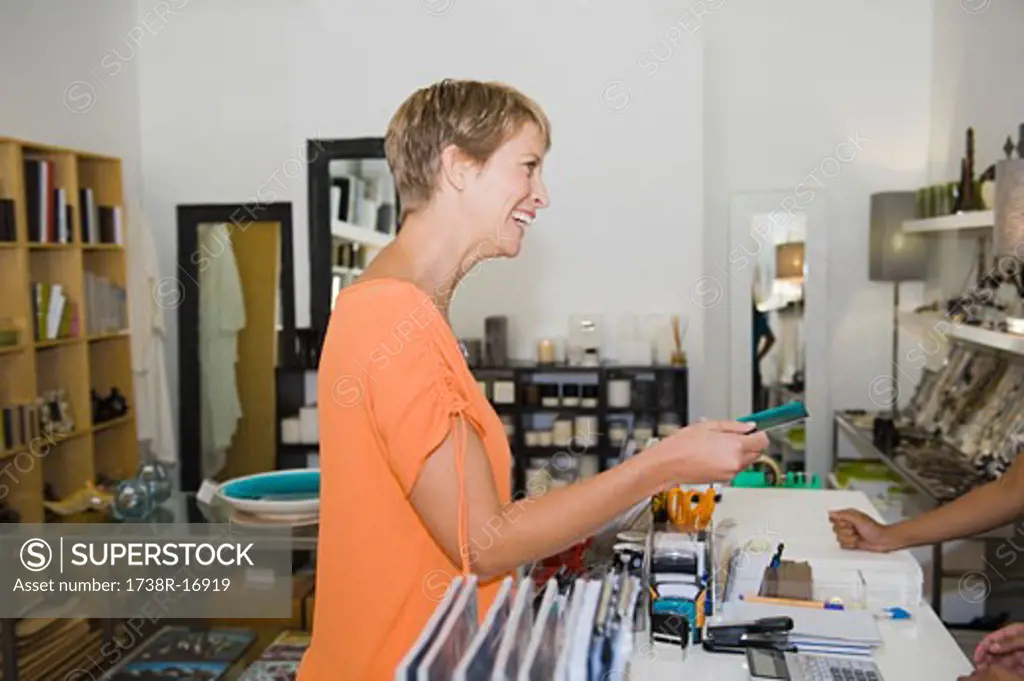 Woman giving credit card to a sales clerk