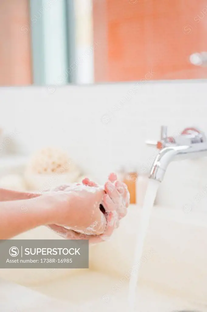 Woman washing hands in the bathroom
