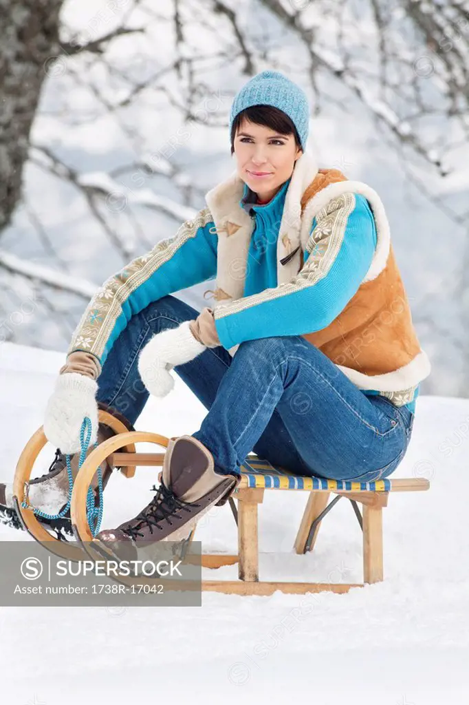 Young woman sitting on sled