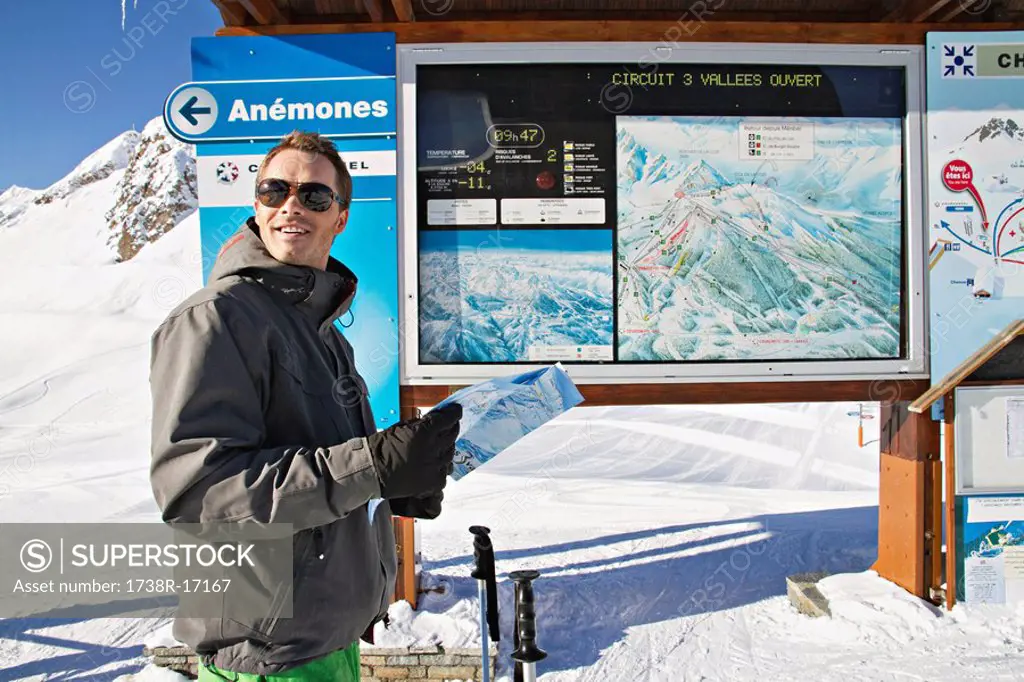 Male skier looking at map, Courchevel, France