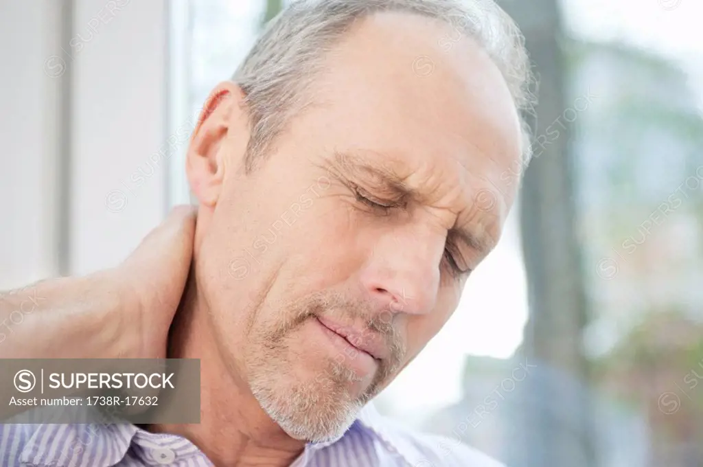 Close_up of a man rubbing his neck