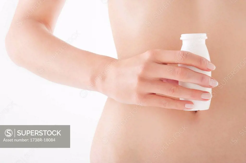 Mid section view of a woman holding a bottle of probiotic drink