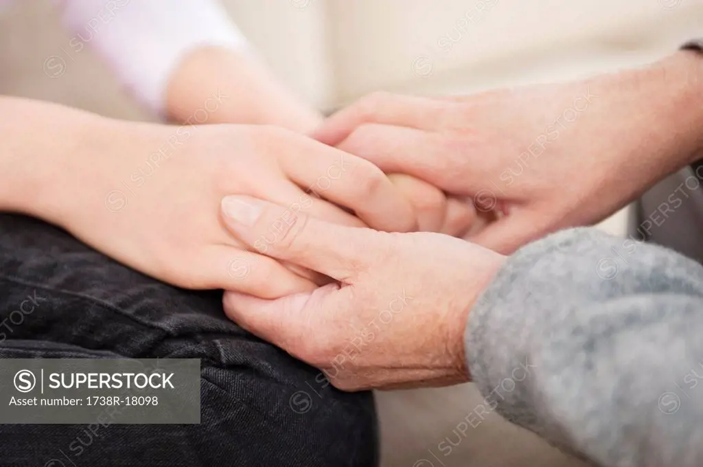Woman holding hands of her granddaughter