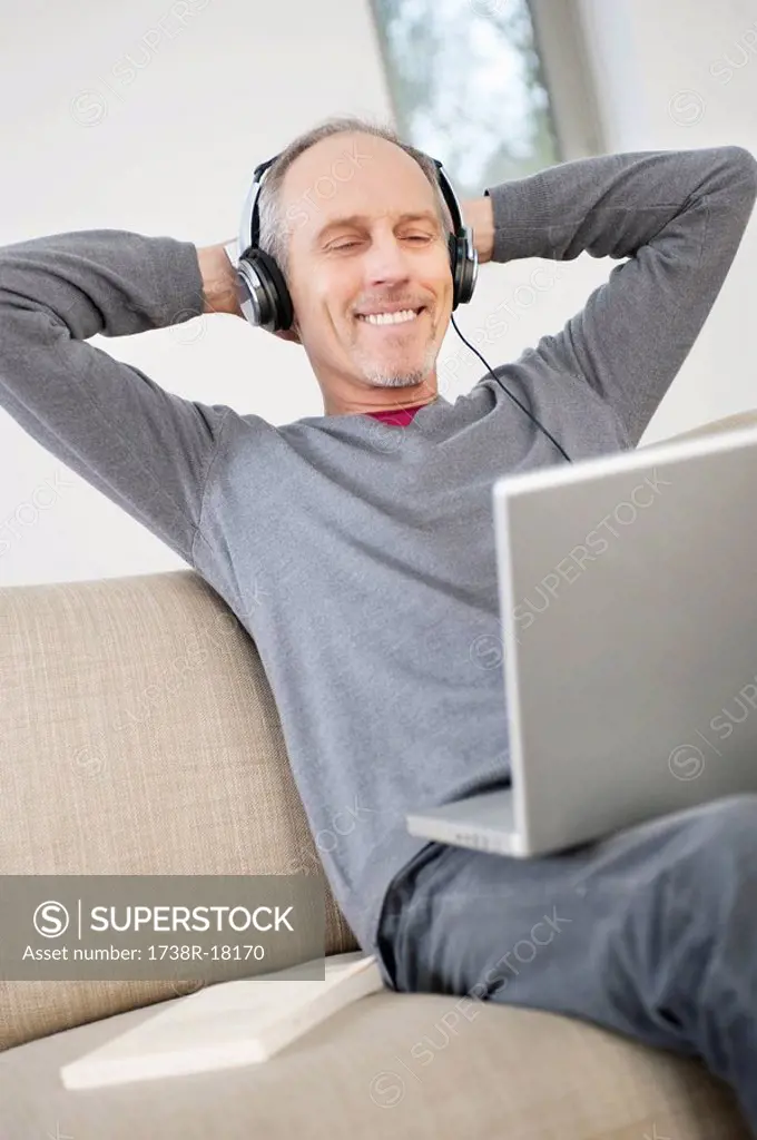 Man using a laptop and listening to music