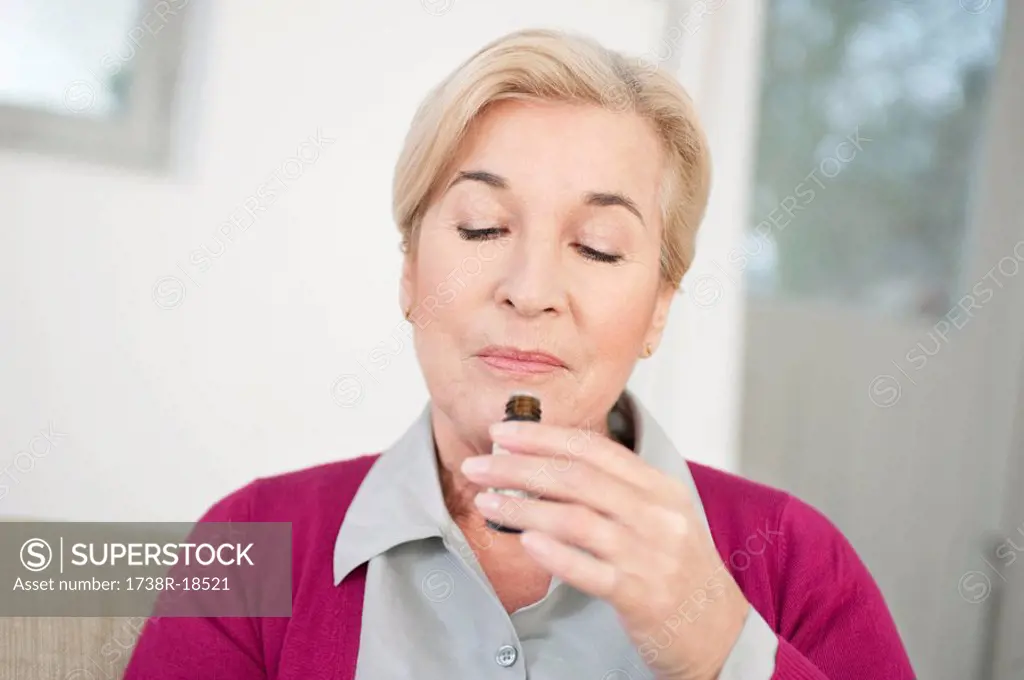 Close_up of a woman smelling aromatherapy oil