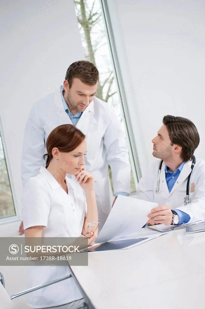 Three doctors examining a medical report
