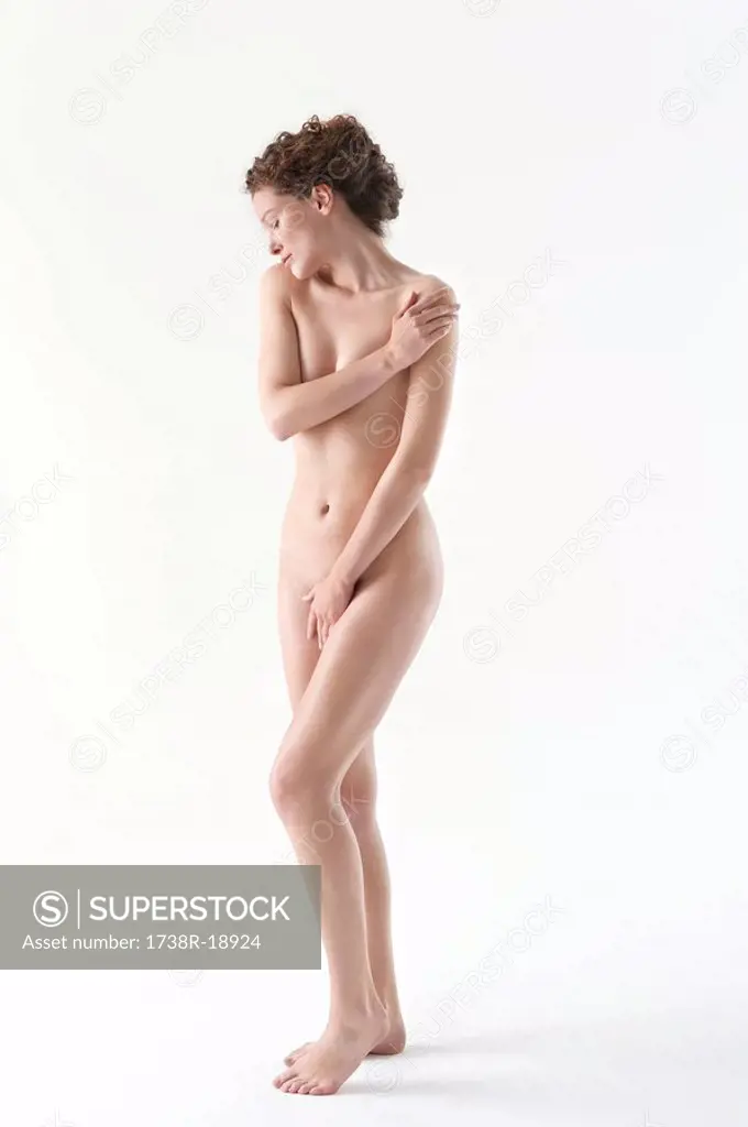 Naked woman covering groin with hand
