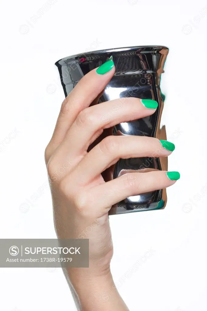 Close_up of woman´s hand holding silver cup