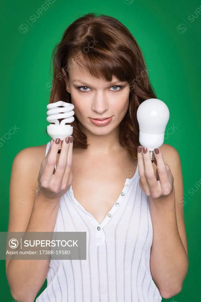 Young woman holding two light bulbs