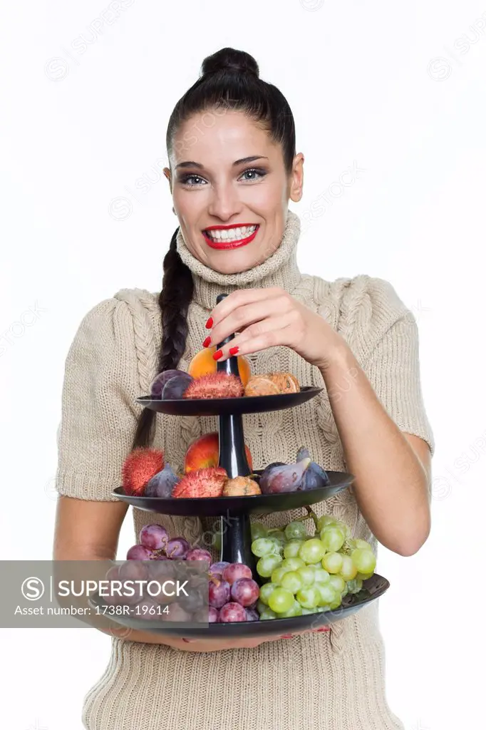 Young woman holding fruit dish