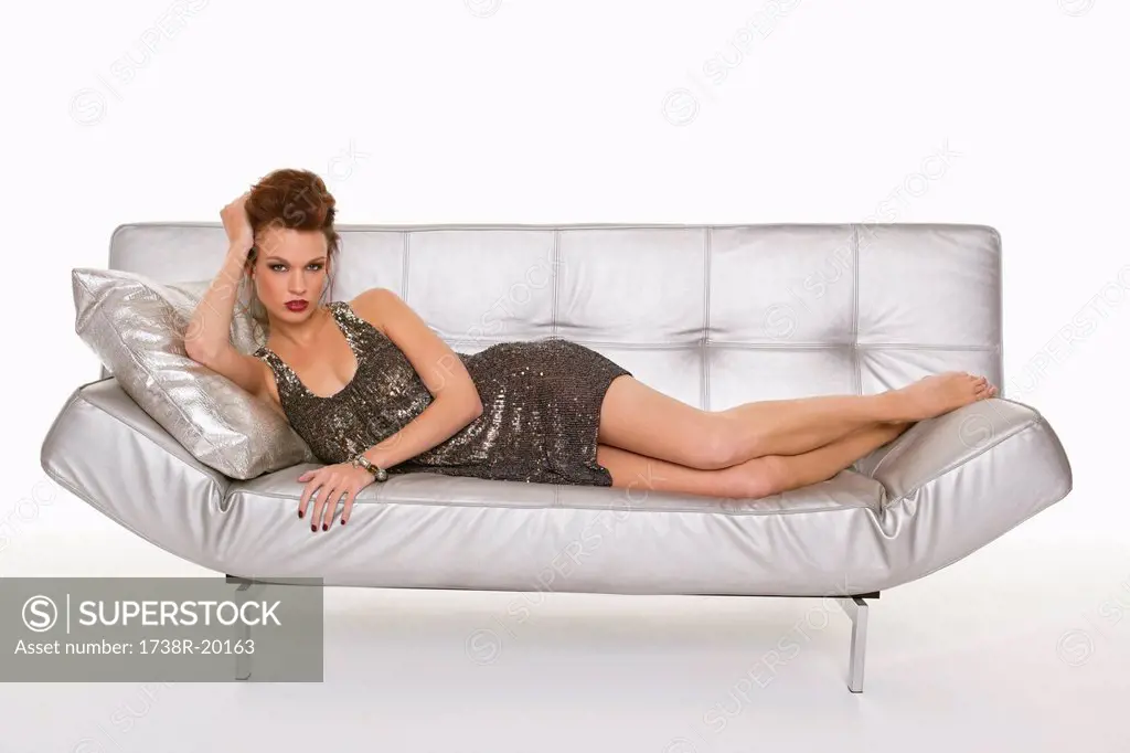 Young woman in formalwear resting on sofa