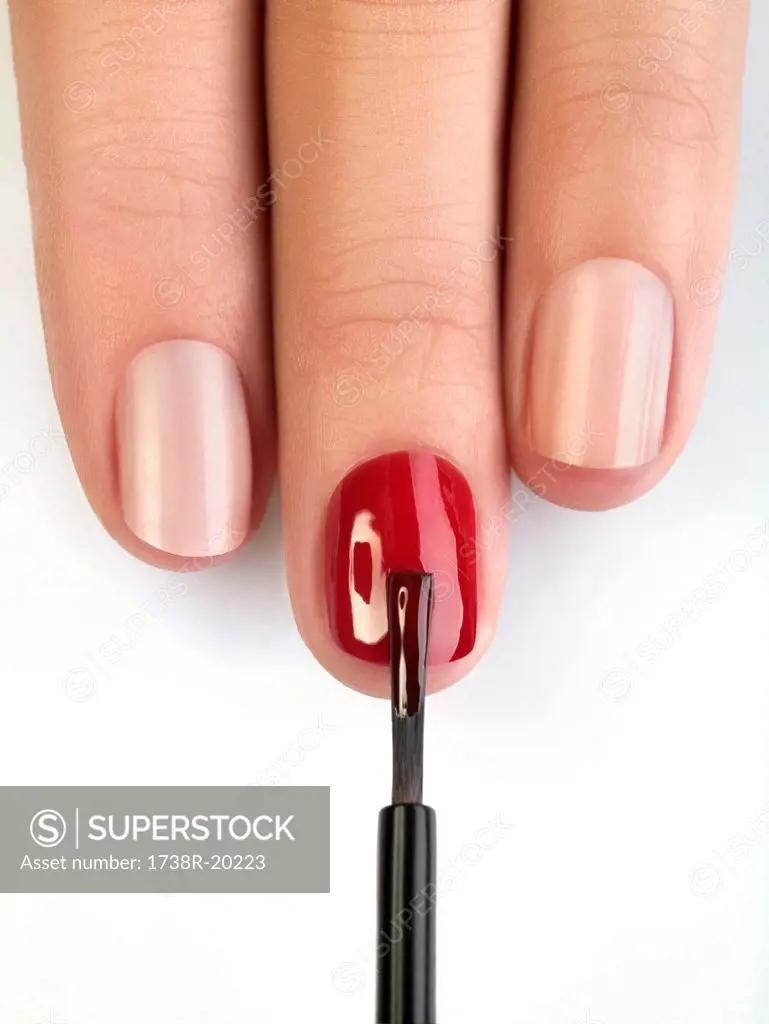 Woman painting fingernails, close_up