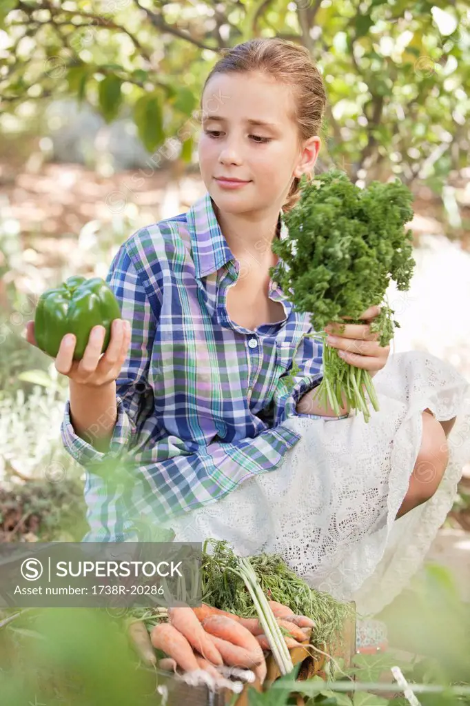 Girl choosing vegetables from a crate
