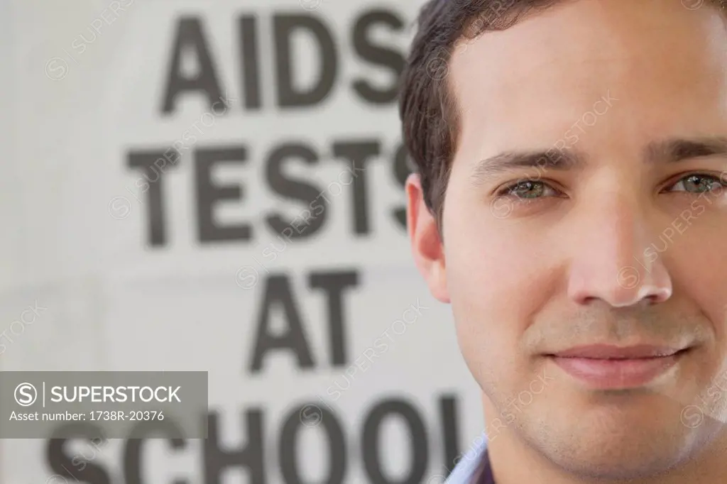 Close_up of a man in front of AIDS awareness poster