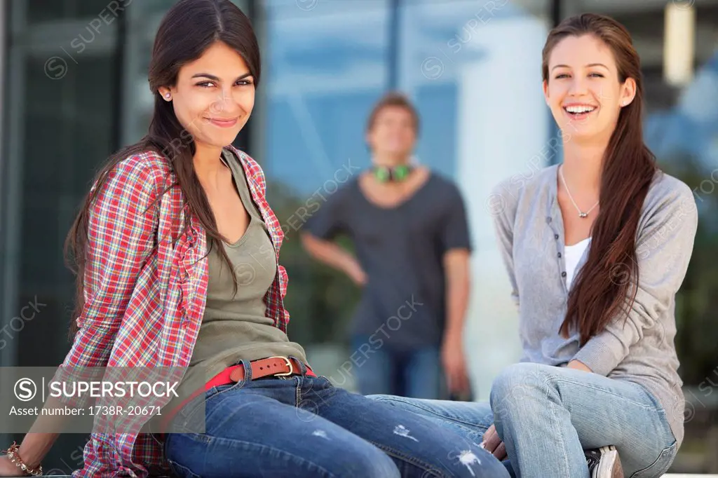 Portrait of two female friends sitting in a campus