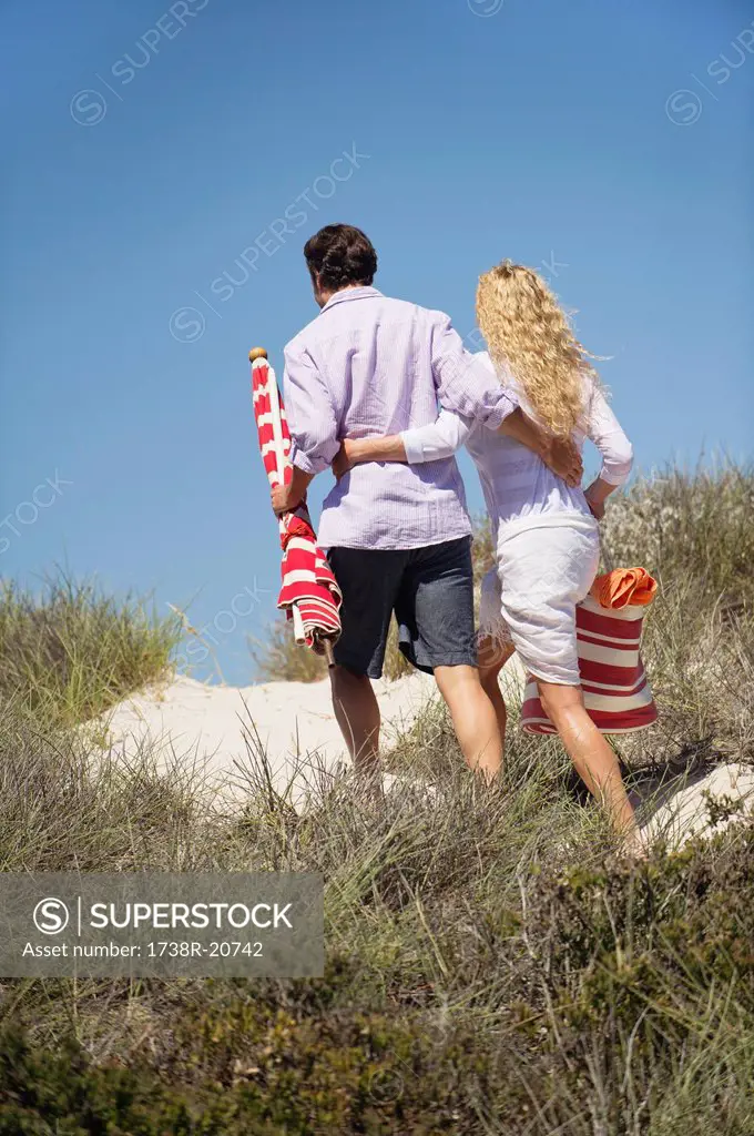 Rear view of a couple walking on the beach
