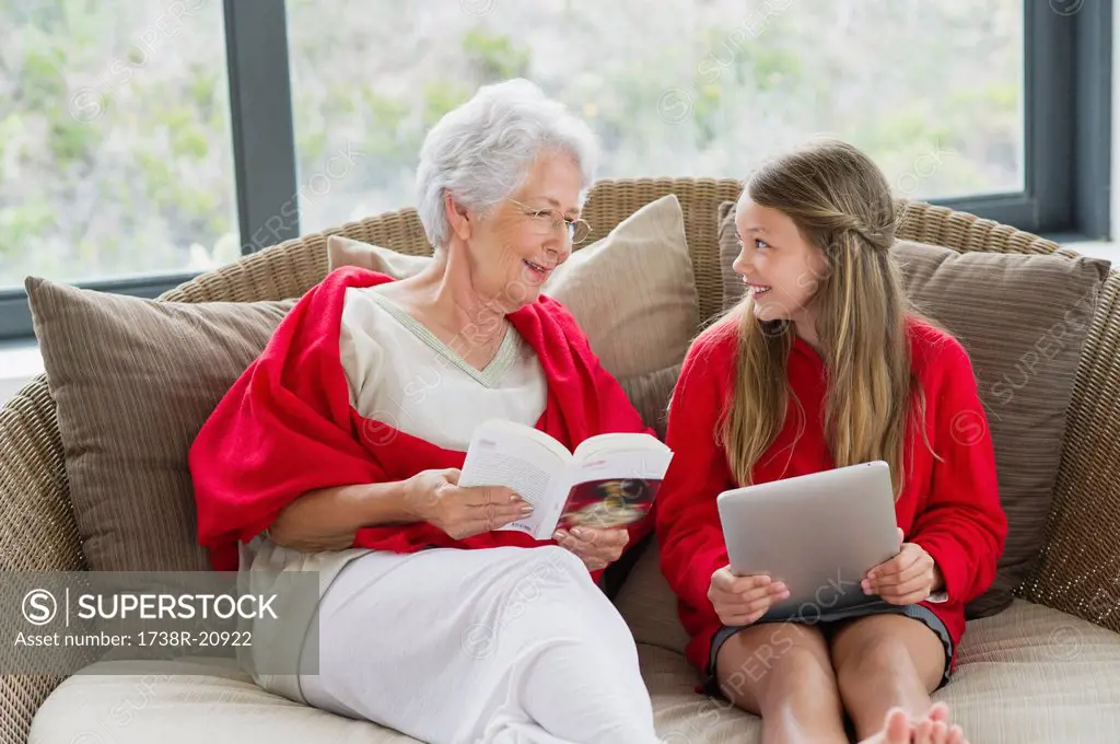 Senior woman and her granddaughter looking at each other and smiling