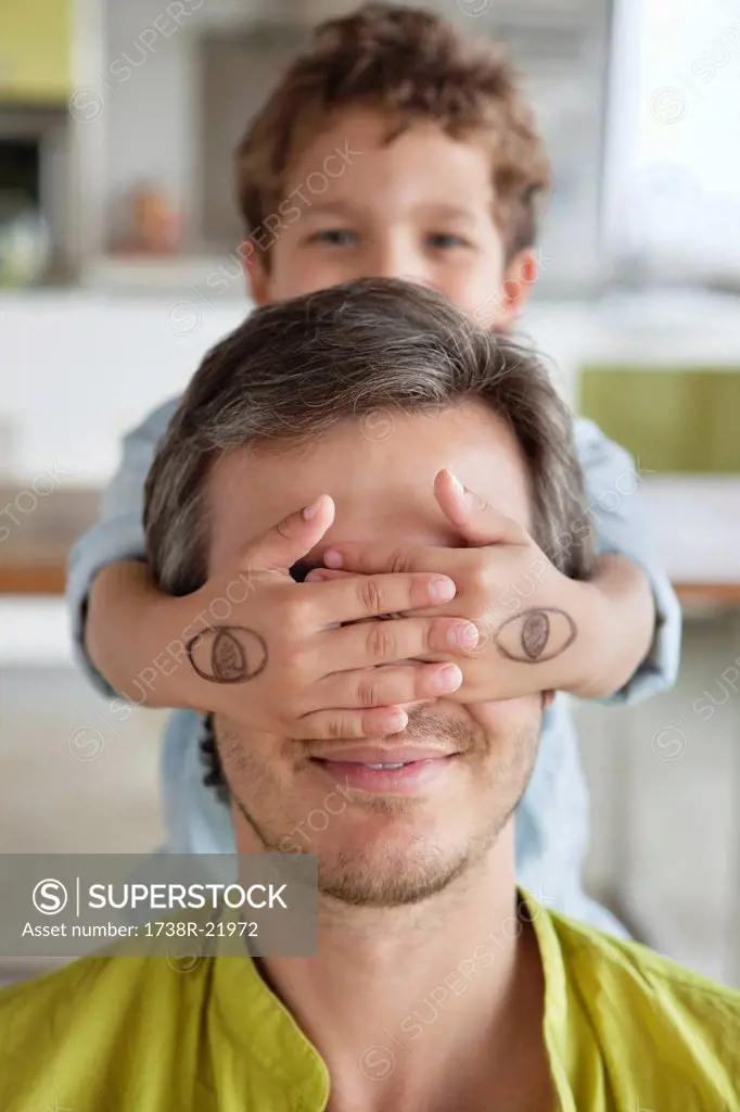 Boy covering his father´s eyes