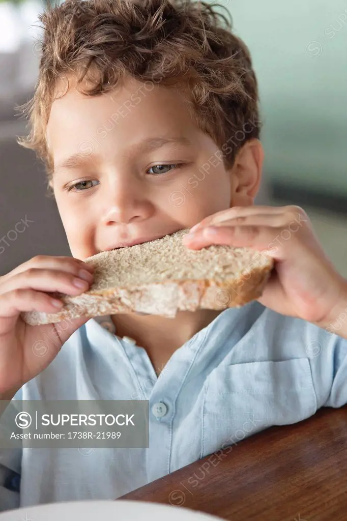 Close_up of a boy eating bread