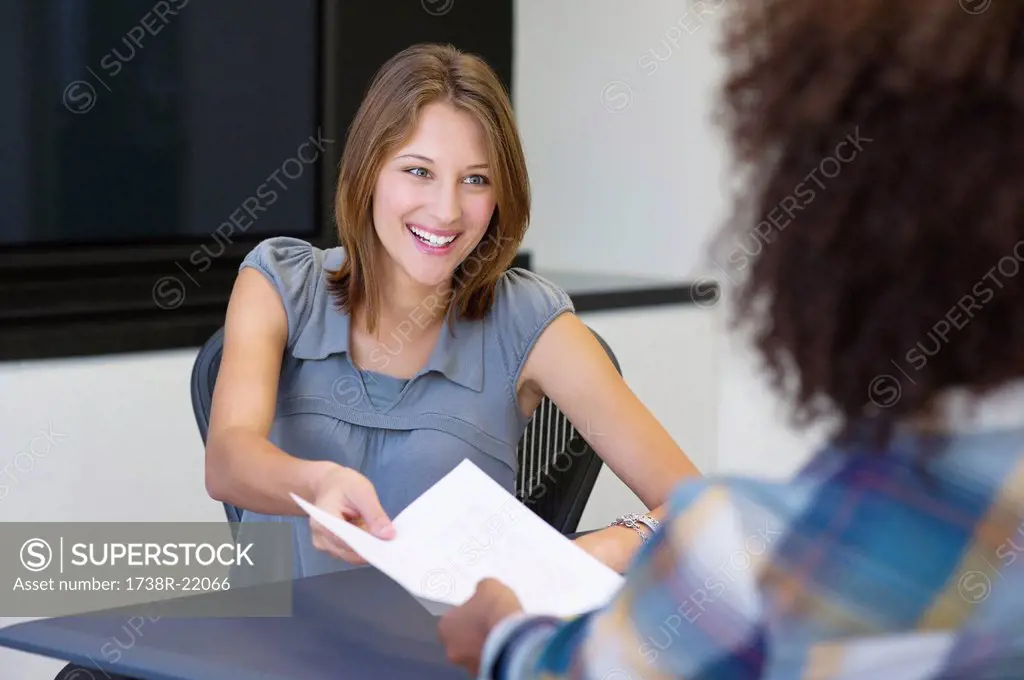 African American woman giving resume to a businesswoman in office