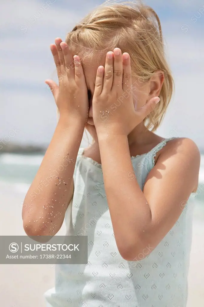 Girl covering her face with hands