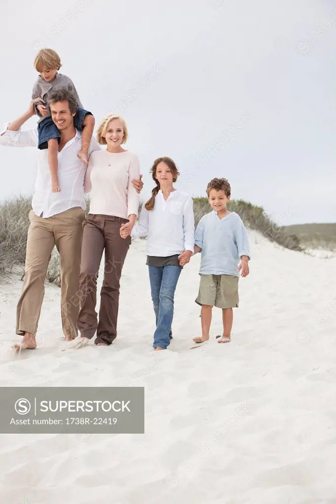 Couple walking on the beach with their children