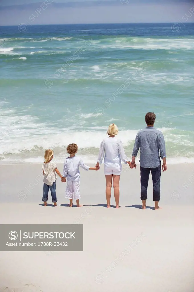 Couple with their children standing on the beach