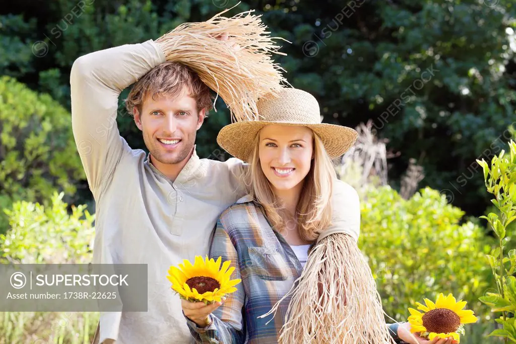 Portrait of a couple in scarecrow pose in a field