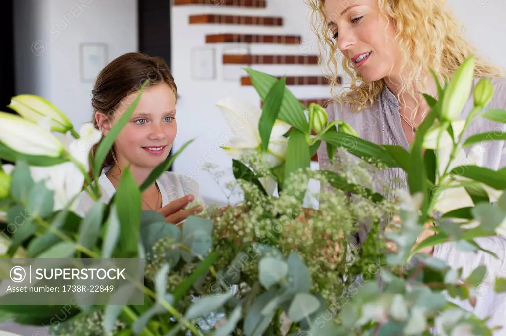 Mid adult woman and her daughter touching leaves