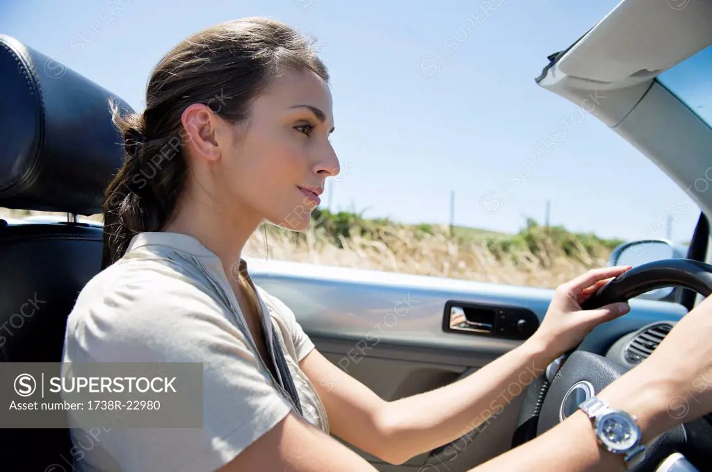 Young woman driving a convertible car