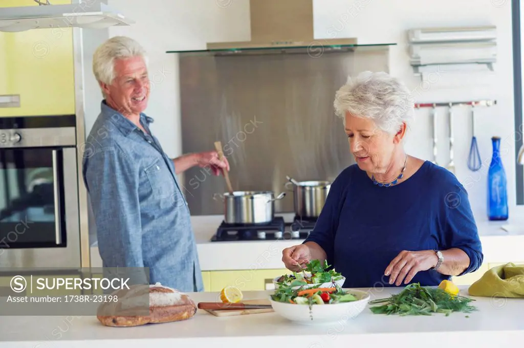 Senior couple preparing food in a domestic kitchen