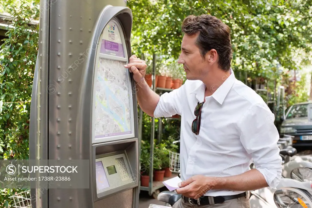 Man looking a map in a ticket machine, Paris, Ile_de_France, France