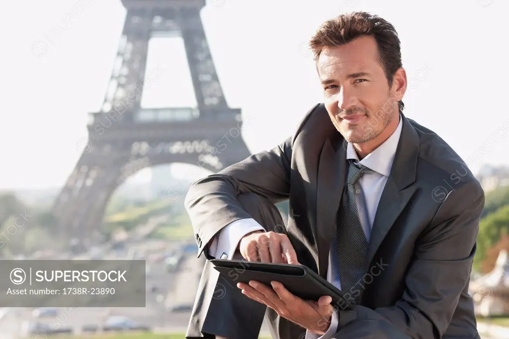 Businessman using a digital tablet with the Eiffel Tower in the background, Paris, Ile_de_France, France
