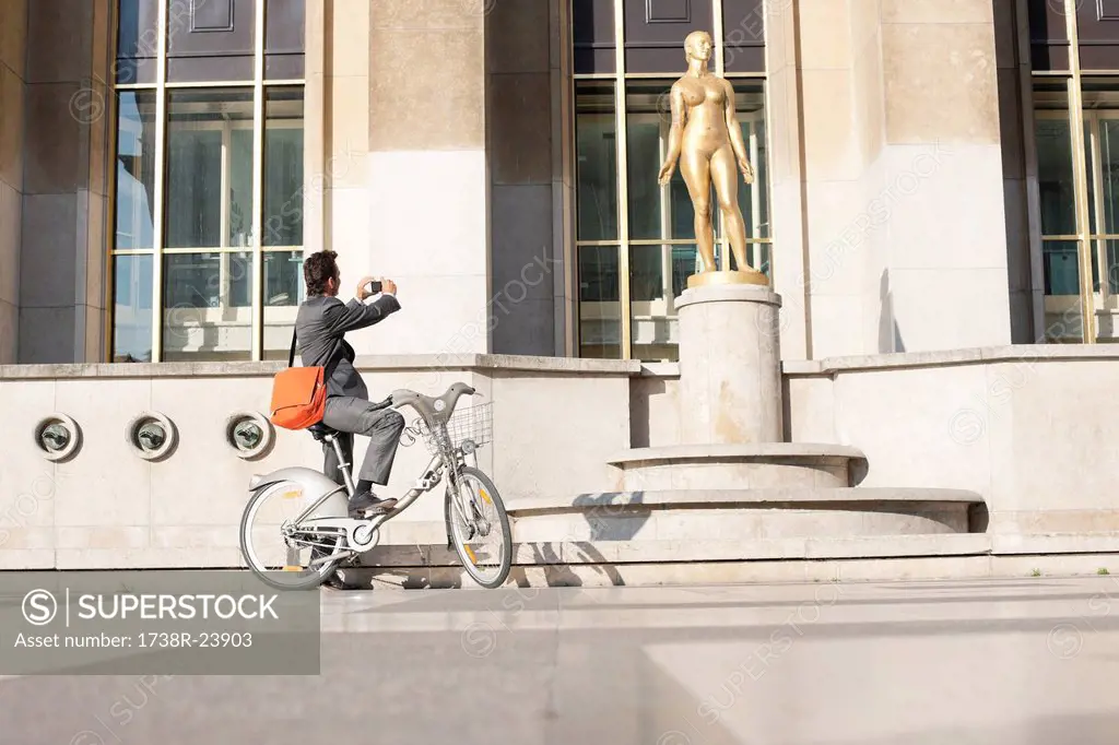 Man on a bicycle taking a picture of a woman´s statue, Palais de Chaillot, Paris, Ile_de_France, France