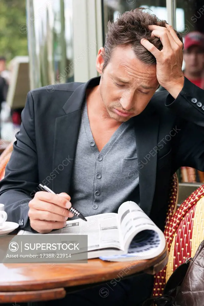 Man reading a magazine looking worried, Paris, Ile_de_France, France