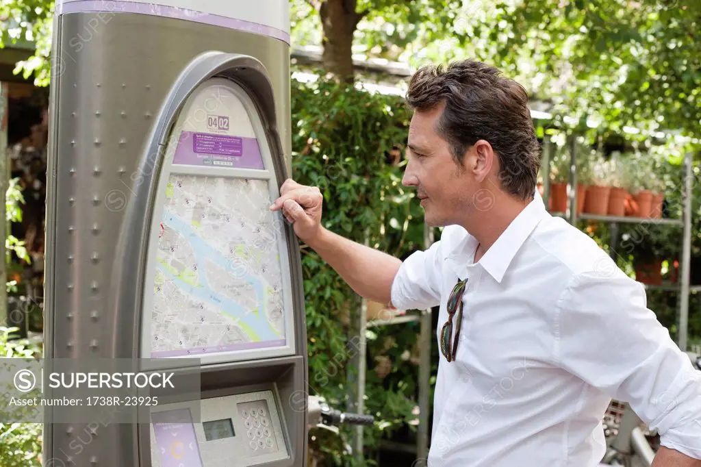 Man looking a map in a ticket machine, Paris, Ile_de_France, France