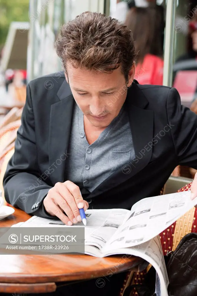 Man reading a magazine in a restaurant, Paris, Ile_de_France, France