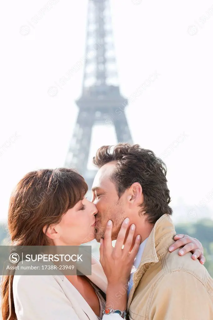 Couple kissing with the Eiffel Tower in the background, Paris, Ile_de_France, France