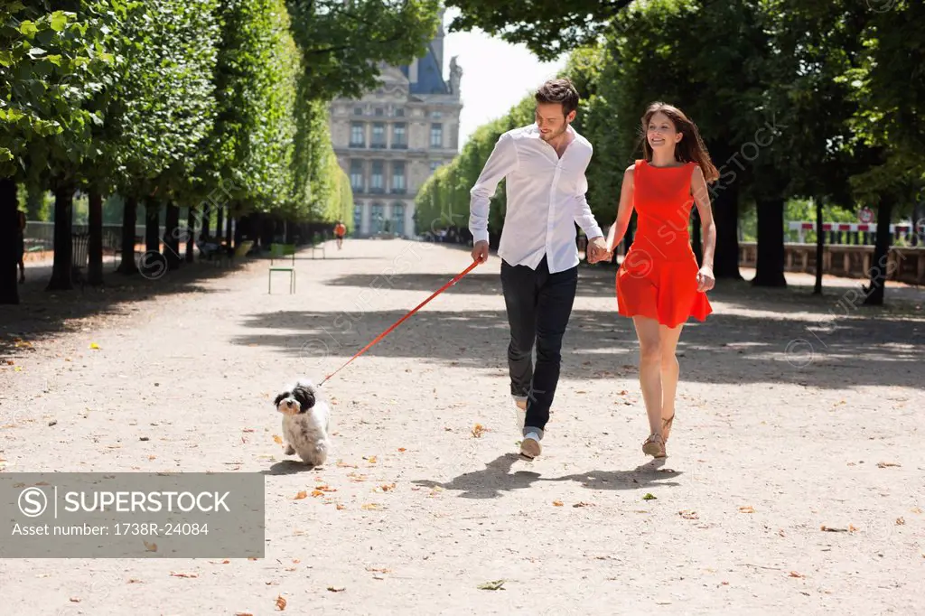 Couple running in a garden with a puppy, Terrasse De l´Orangerie, Jardin des Tuileries, Paris, Ile_de_France, France