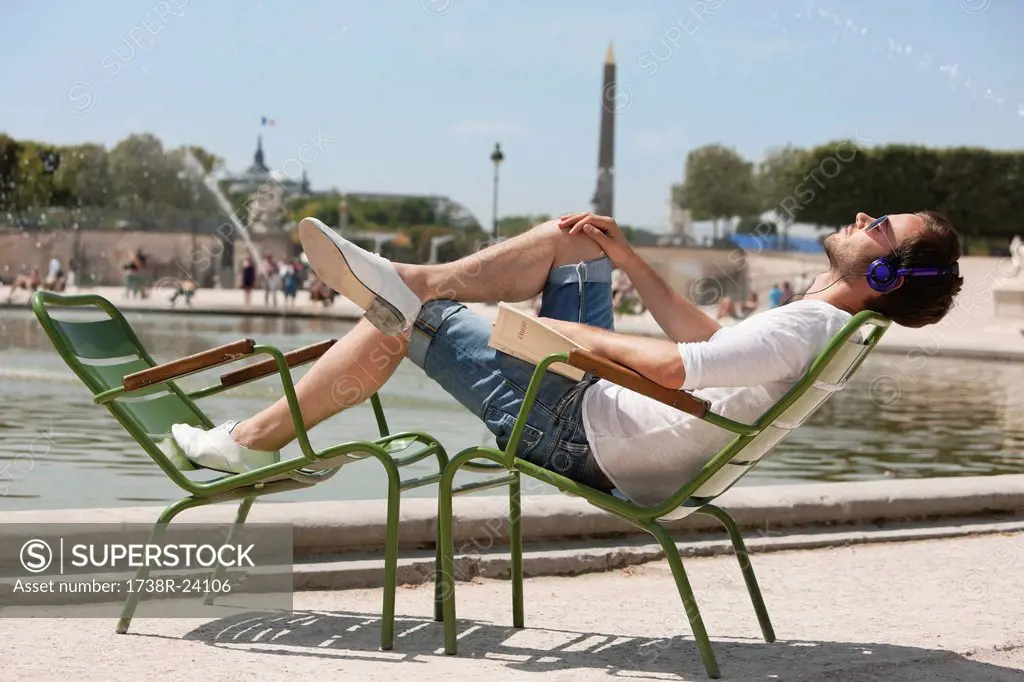 Man reclining in a chair and listening to music, Bassin octogonal, Jardin des Tuileries, Paris, Ile_de_France, France