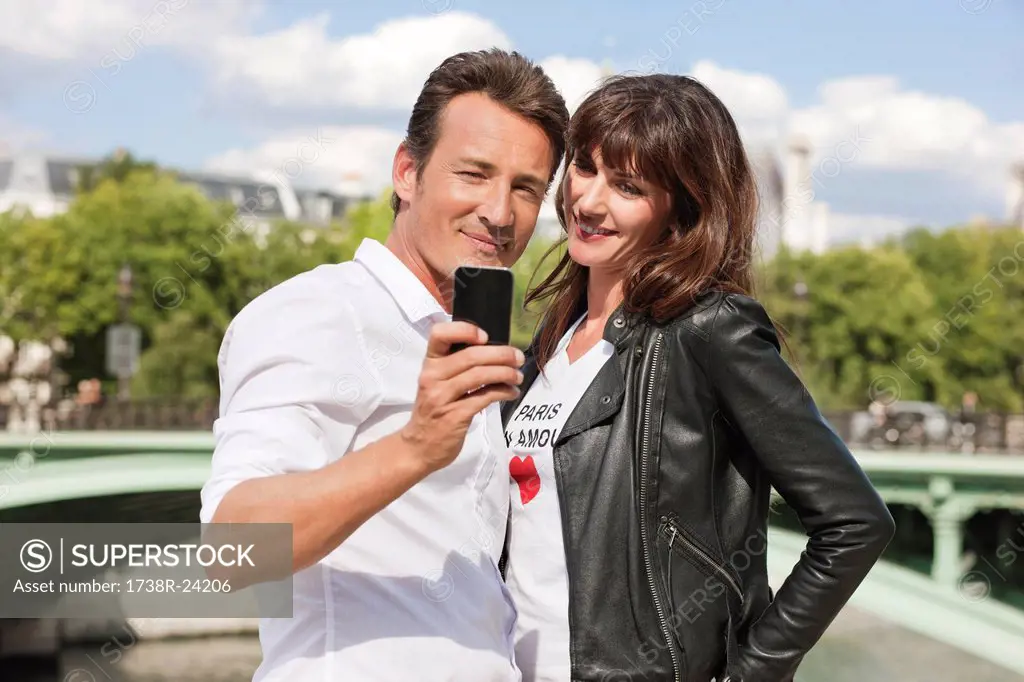 Couple taking a picture of themselves with a mobile phone, Seine River, Paris, Ile_de_France, France
