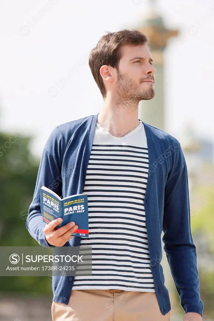 Man holding a travel guidebook, Paris, Ile_de_France, France